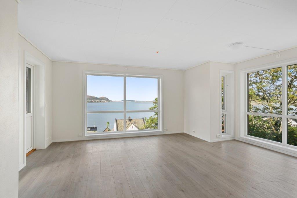 Romsleg og lys stove med vindauge til taket. Foto.