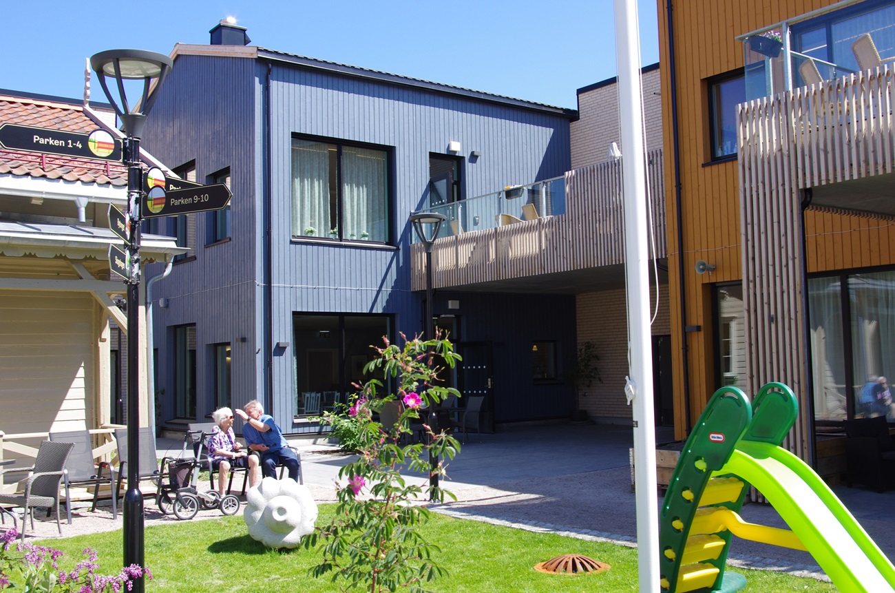 Bilde av boliger med uteplass og lekeaparater foran. Foto.