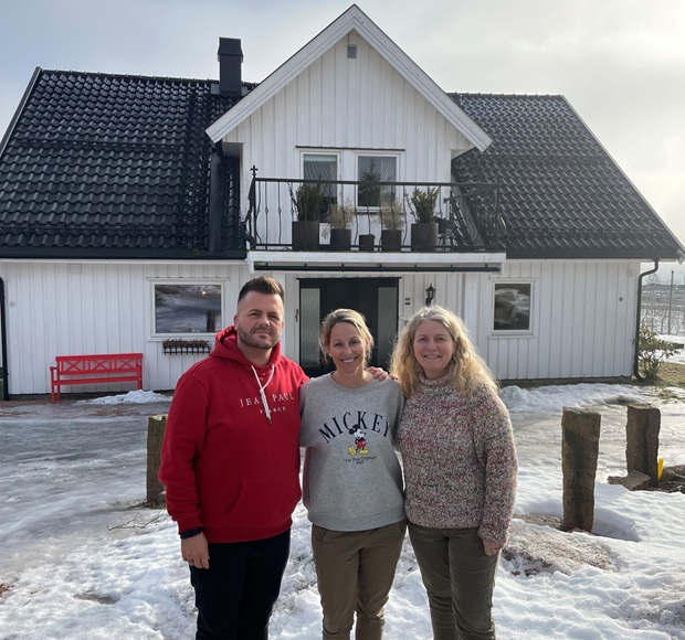 De tre ansatte Remi, Mari og Ingrid foran det ombygde hovedhuset. Foto.
