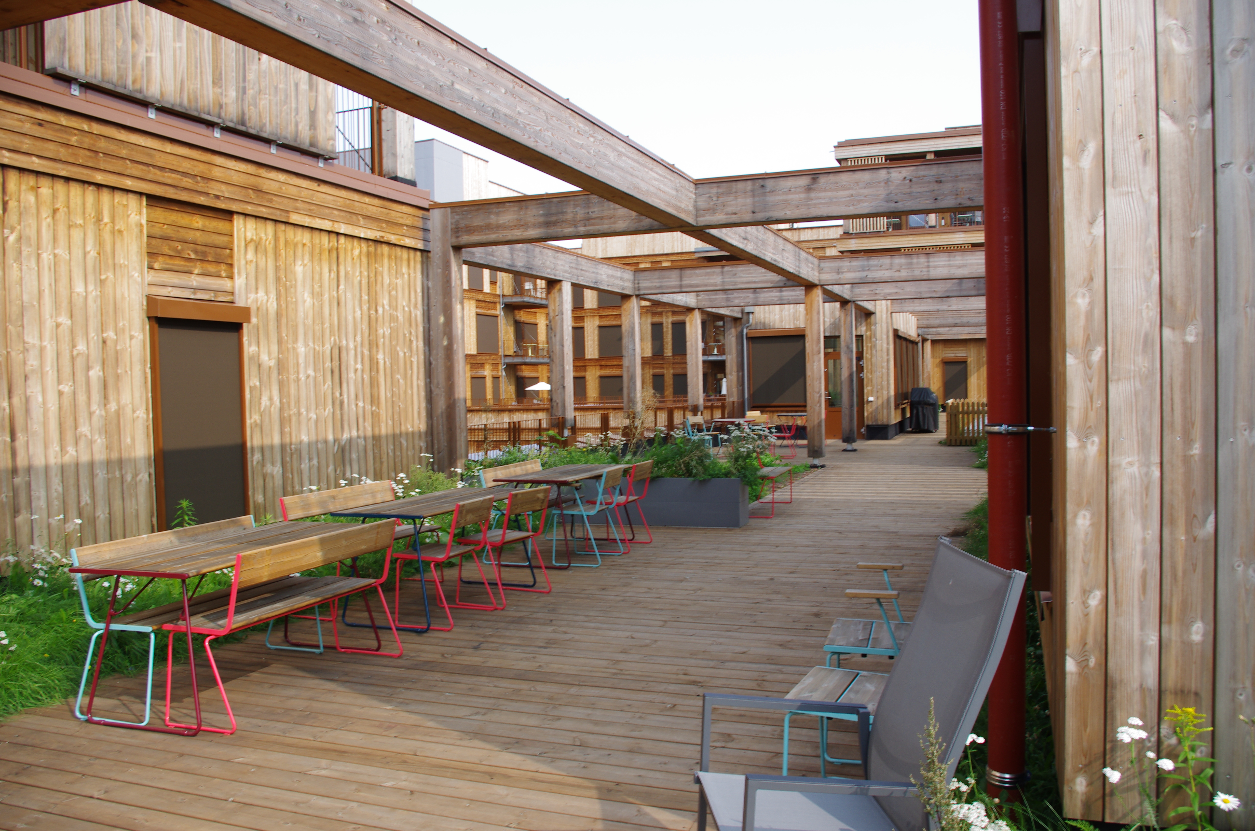 Uterom terrasse mange sitteplasser og bord. Foto.