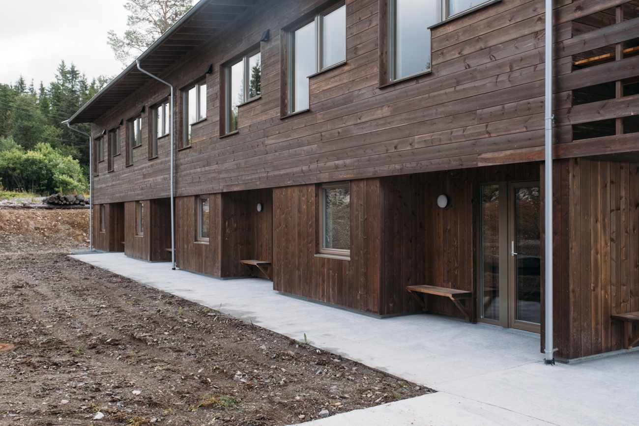 Hybelbygg inngangsparti, mørk brun massivtre fasade. Foto.