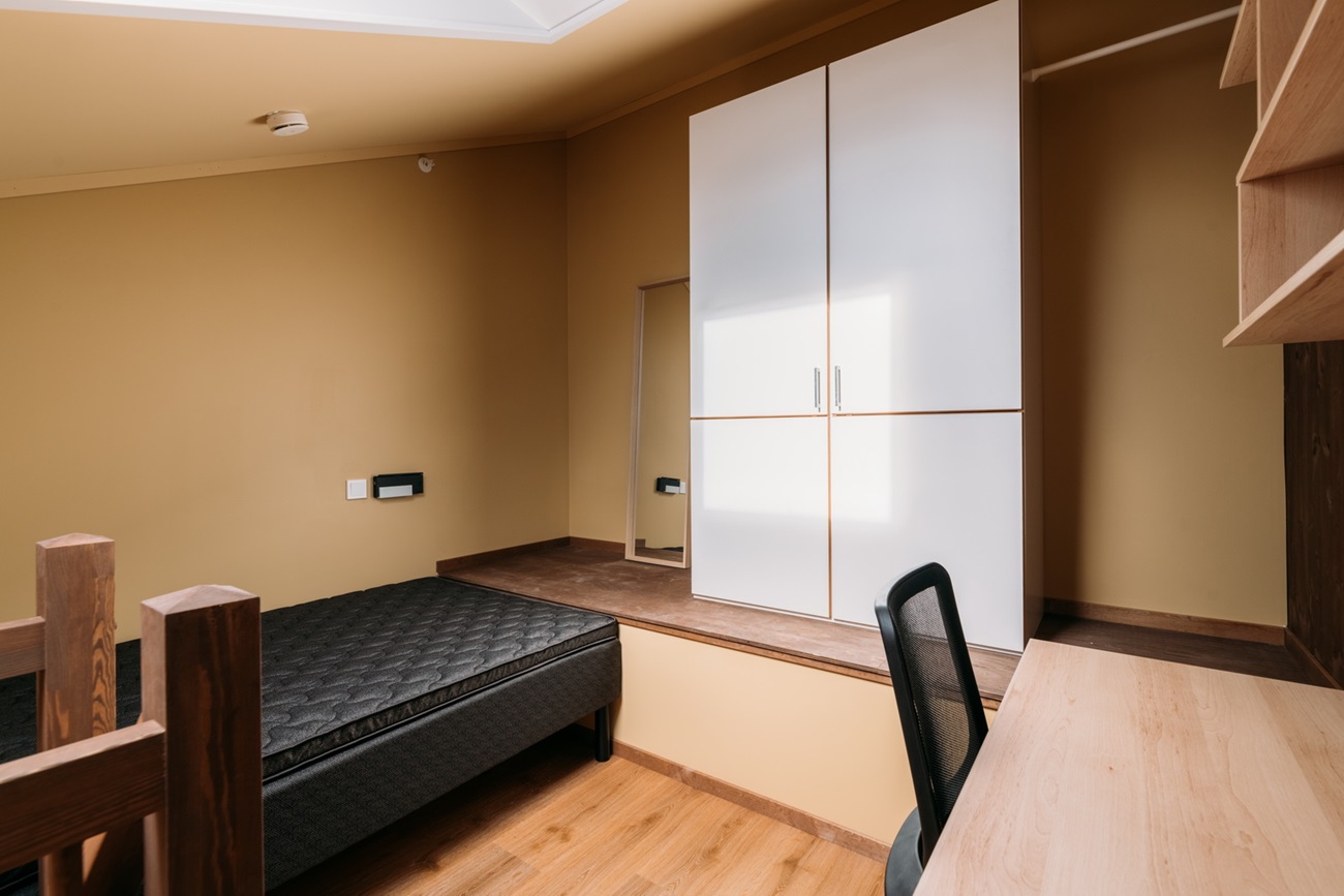 Hems med seng, skap og pult. Foto.