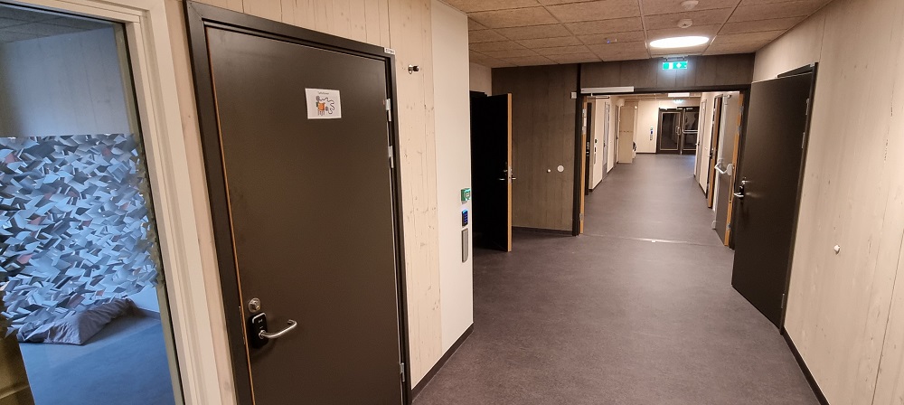 Lys og romslig korridor med dører til aktivitetsrom. Foto. 