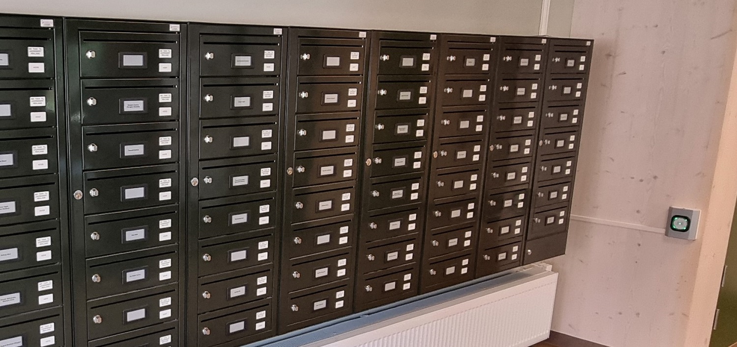 Elektroniske postkasser på veggen med kortleser for å åpne. Foto. 