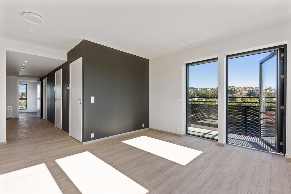 Tom leilighet med gang, stue og utgang balkong. Foto.