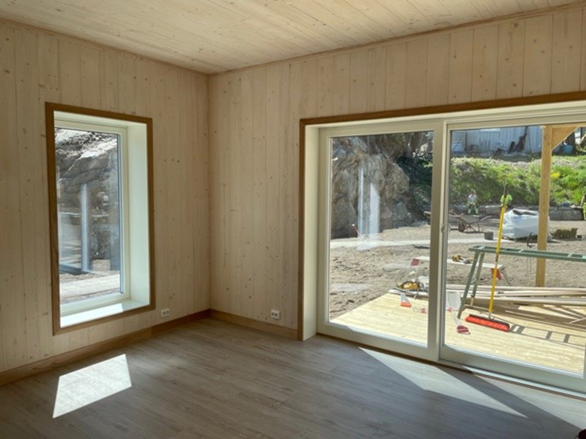 Stue i en leilighetene, med utgang til felles hage. Foto.