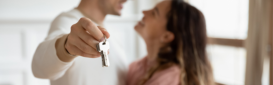 bilde av mann og dame som står sammen. mannen holder en husnøkkel i hånden. 